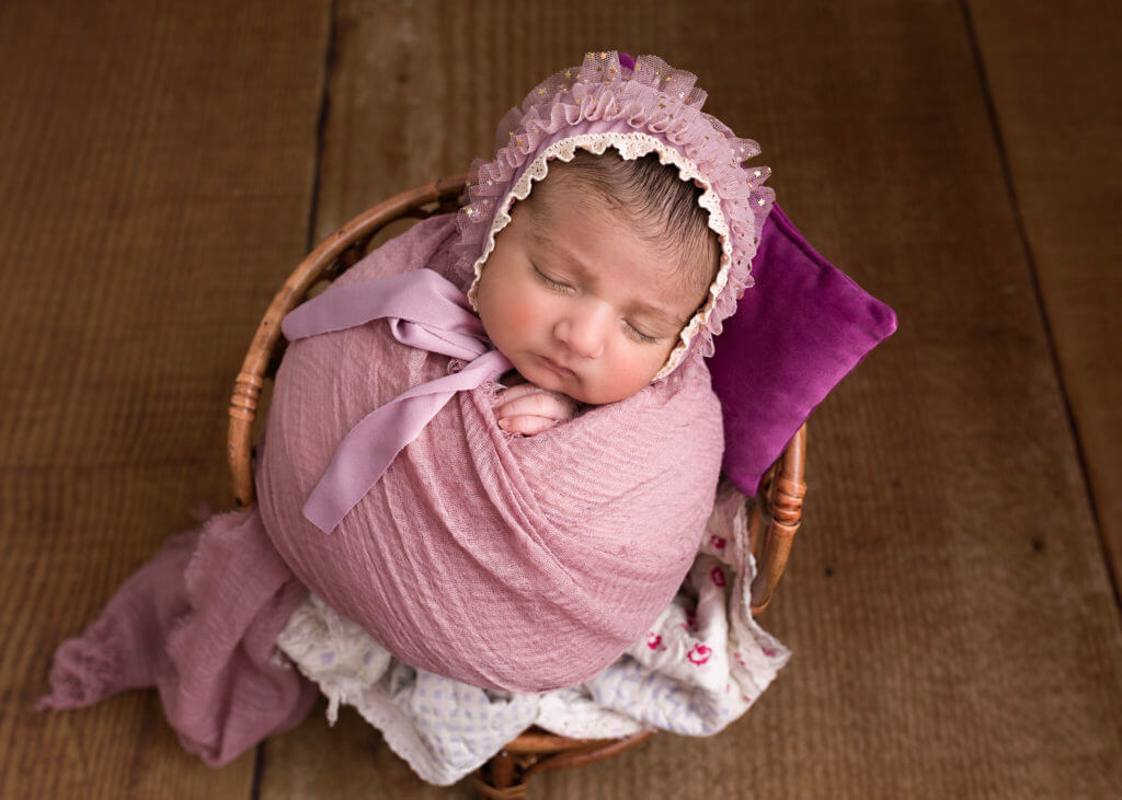 Newborn baby girl I'm pink swaddle on a little chair Newborn Photography Great Barr Birmingham